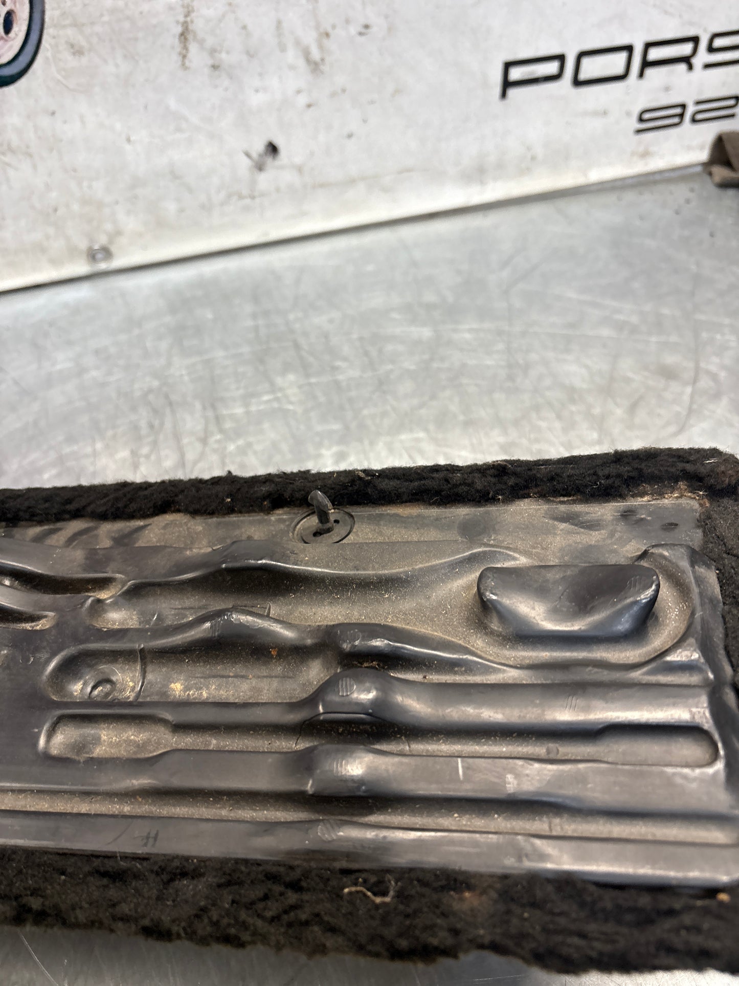 Porsche 928 black/grey-beige carpeted Tool kit panel cover, used 92855118105